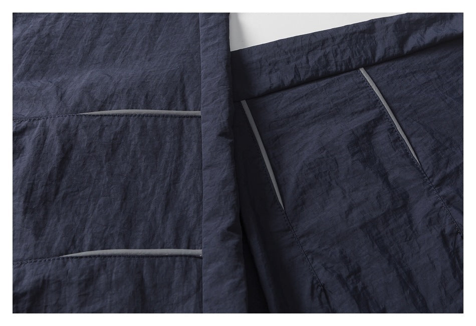 Close-up of the dark pants' panel seams and narrow gray trim.