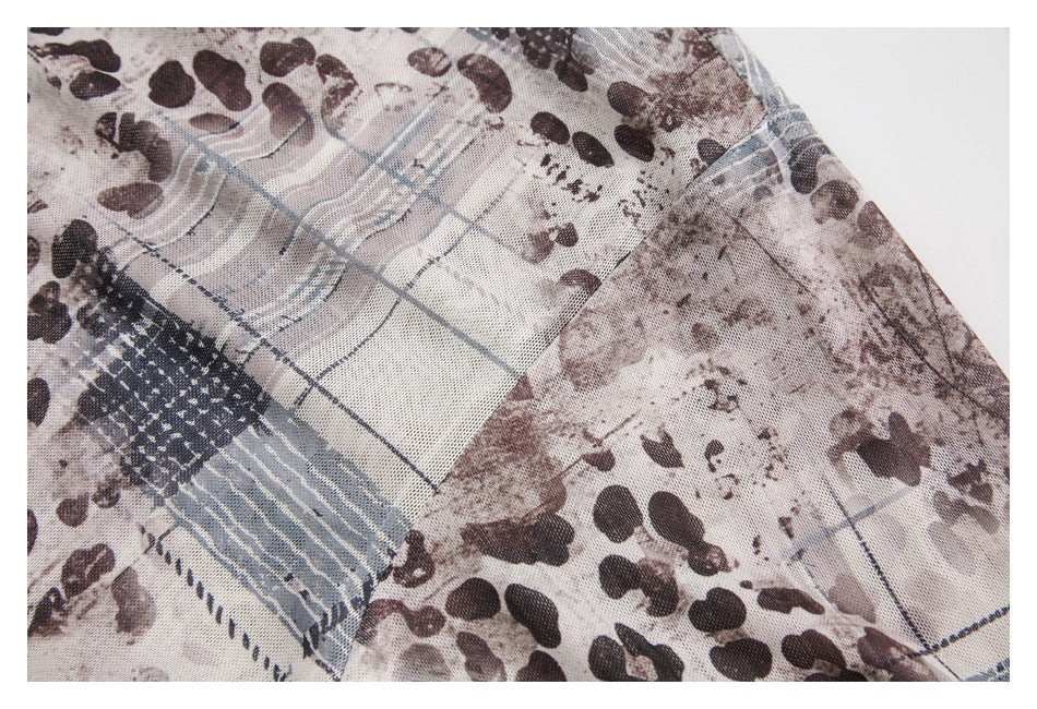 Close-up of the shirt's printed fabric and seam, with abstract brown, gray, and blue patterns.