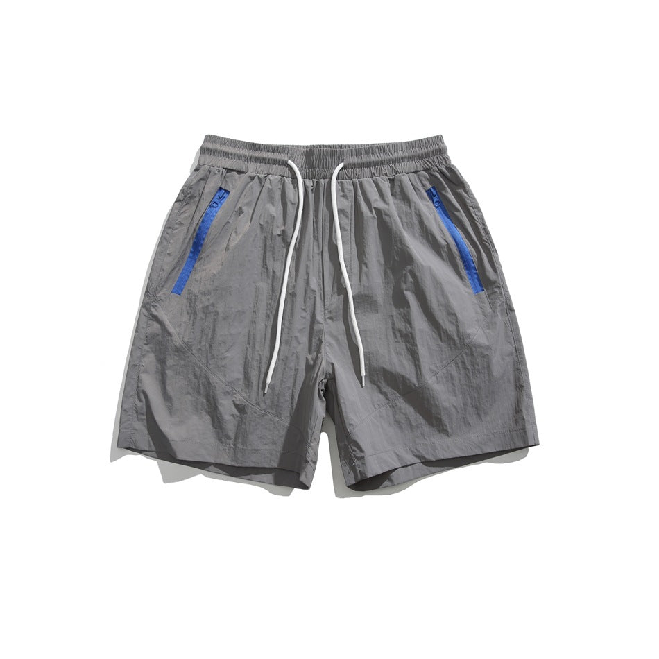 Light gray drawstring shorts with blue zipper-tape pockets, flat lay front view