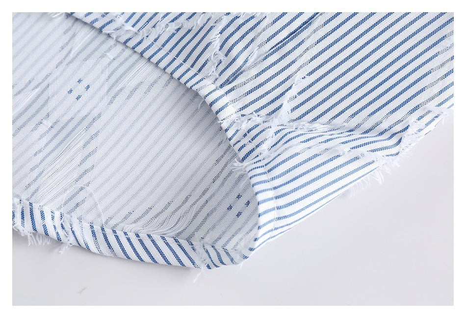 Close-up of the reverse side and seam of blue-and-white striped fabric with frayed edges.