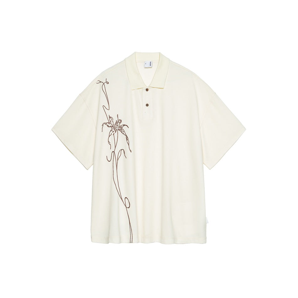 Cream short-sleeve polo top with two brown buttons and a brown line-drawn lily design down the left front