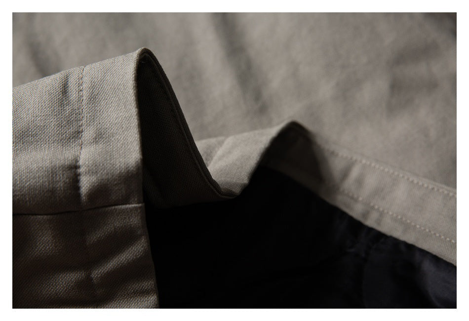 Close-up of beige garment fabric with stitched seams and a dark inner lining.