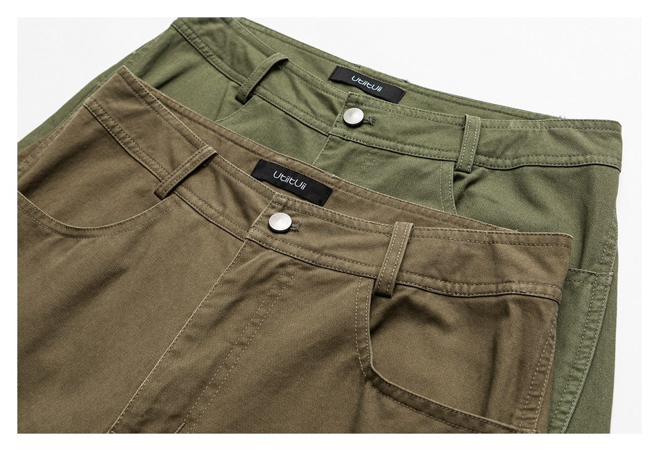 Olive-green and brown trousers overlapped, showing the front waistbands, belt loops, buttons, and pockets.