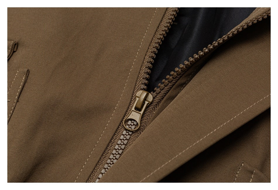 Close-up of a brown garment's zipper, stitching, and dark inner lining.