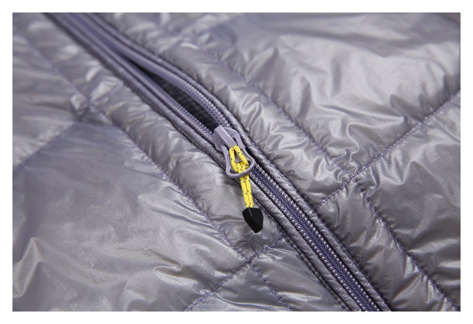 Close-up of a gray quilted jacket zipper with a yellow cord pull and black end cap.
