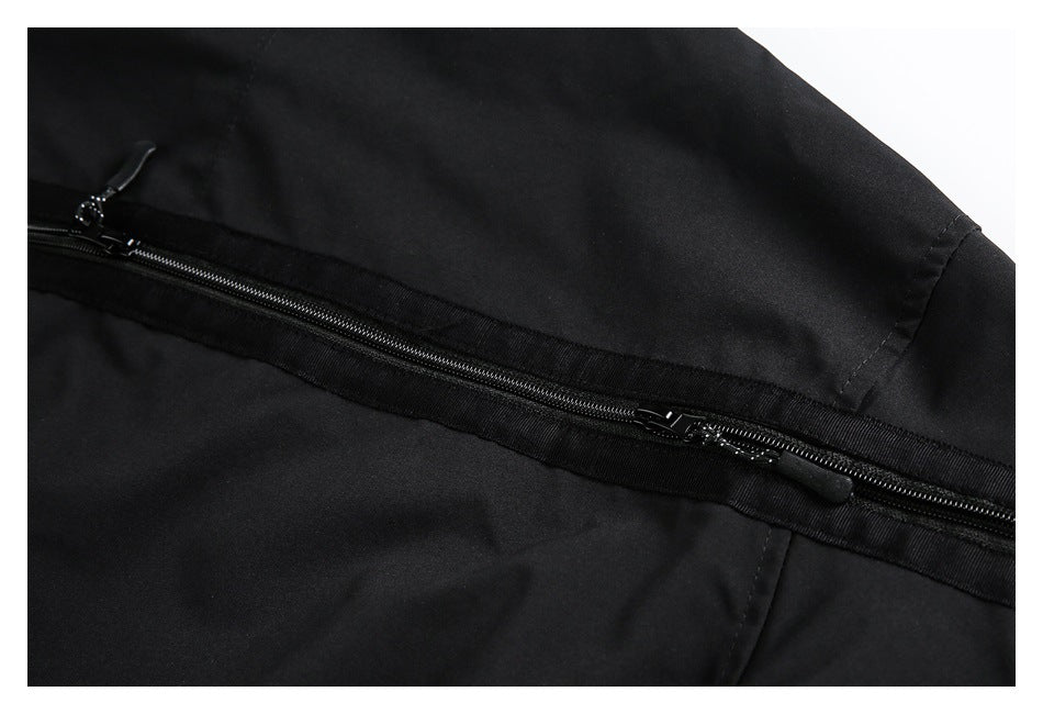 Close-up of a long horizontal black zipper with two pulls across a black garment.
