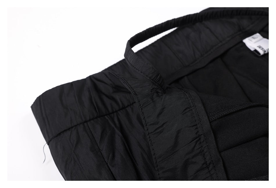 Inside close-up of black trousers showing the waistband seams and a small sewn-in label.
