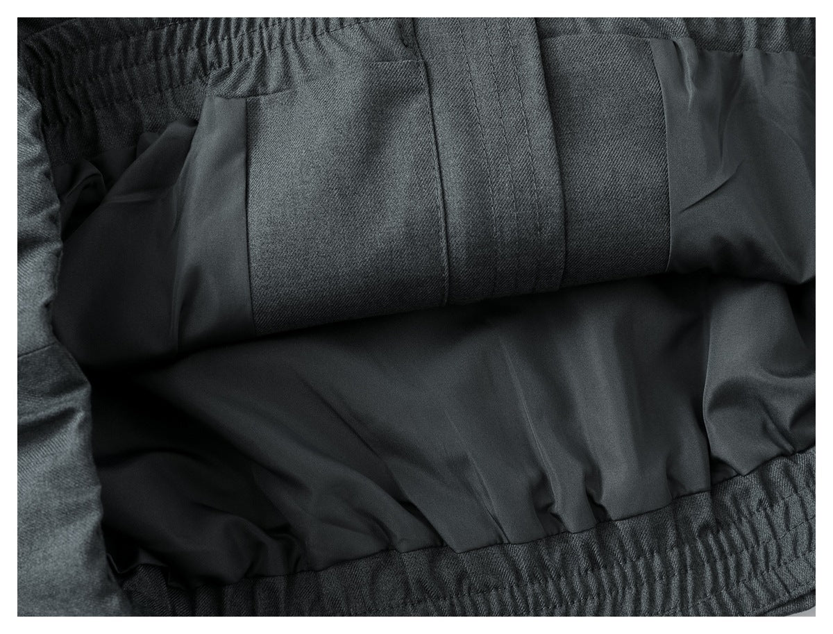 Close-up of the garment interior, showing dark lining, stitched panels, and an elastic waistband.