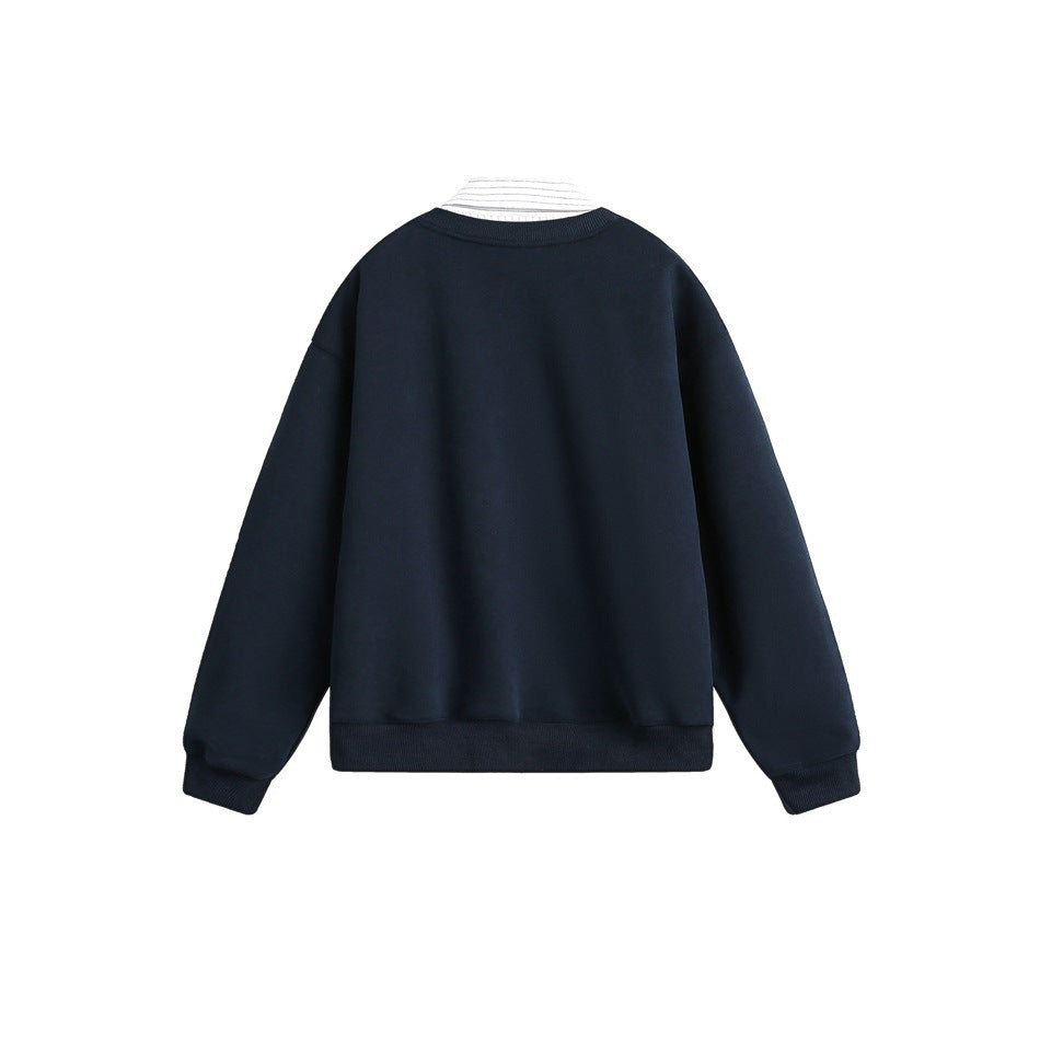 Back view of a dark navy sweater with ribbed cuffs and hem; a striped shirt collar peeks out.