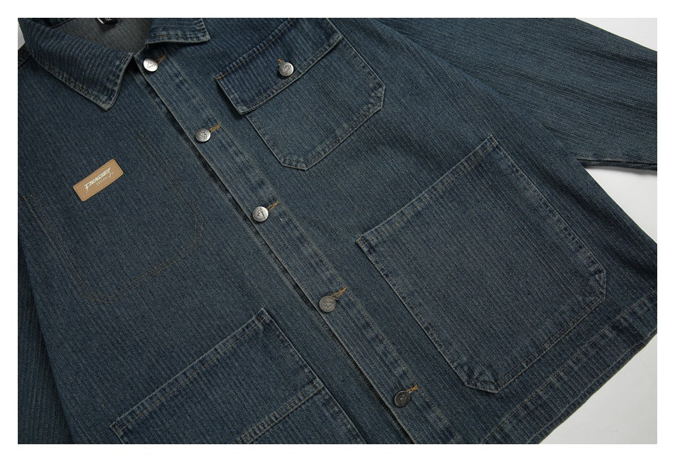 Front view of a dark blue denim jacket laid flat, with a button front and several patch pockets.