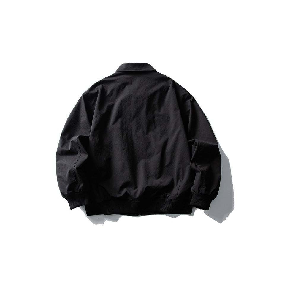 Black jacket back view showing plain back, turn-down collar, ribbed cuffs and ribbed hem, flat lay