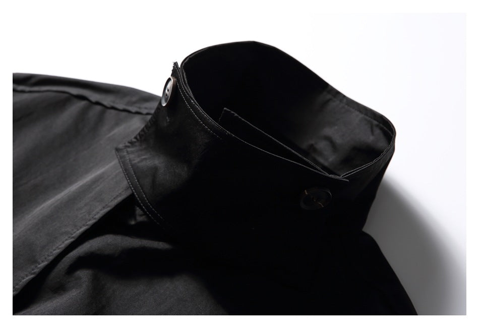 Close-up of the black garment's raised collar, showing its shape, stitching, and buttons.