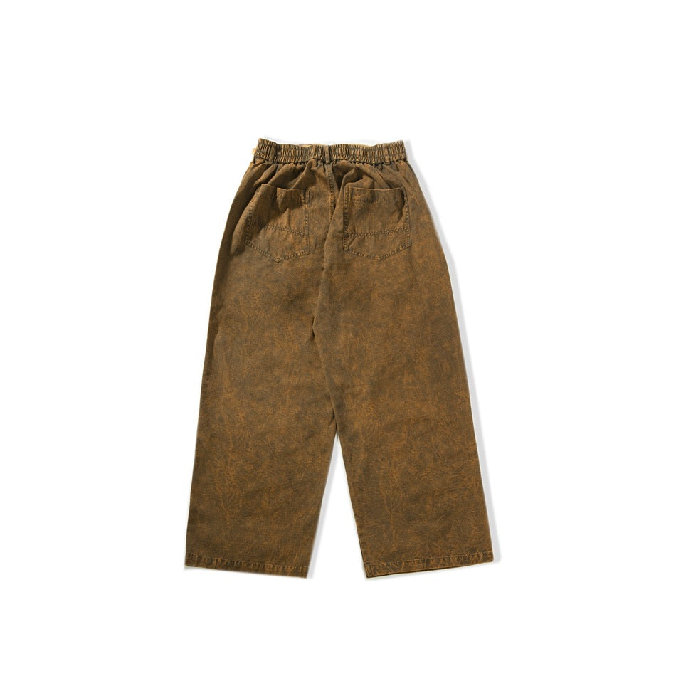 Flat-lay back of brown washed wide-leg pants with elastic waistband and two patch back pockets