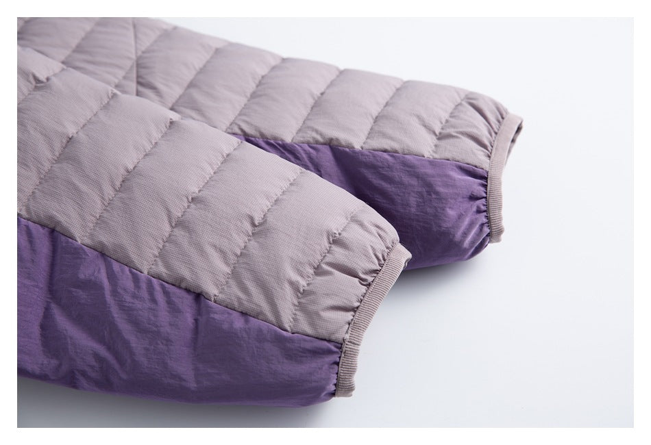 Close-up of a mauve quilted jacket sleeve with purple fabric and ribbed cuff trim.