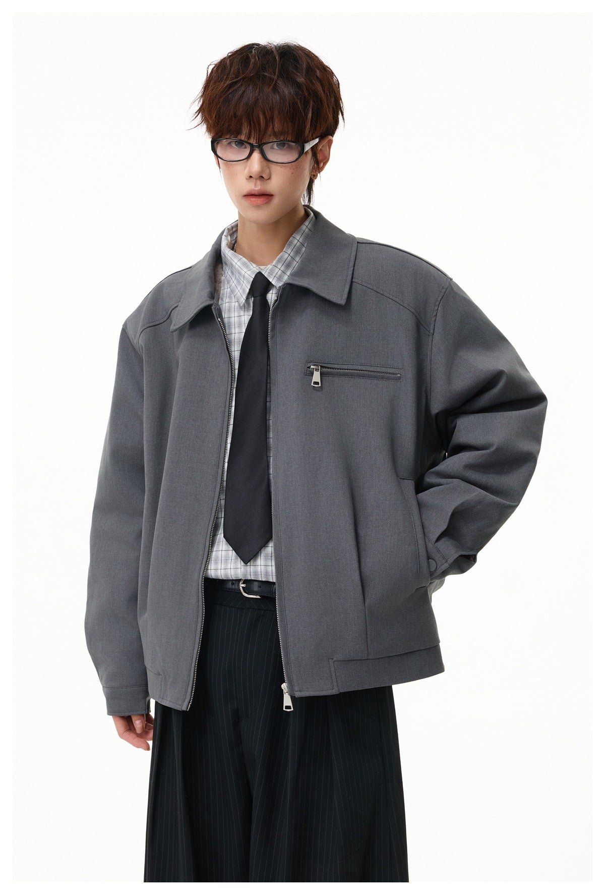 Model wearing a charcoal zip jacket with a pointed collar, chest zip pocket, and relaxed sleeves.