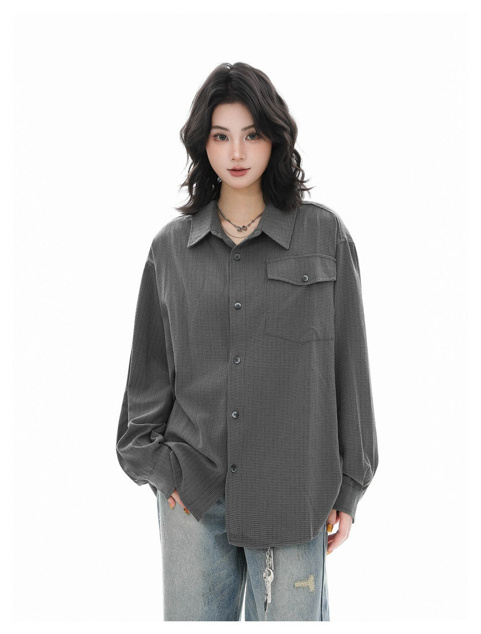 Model wearing an oversized charcoal gray button-up shirt with a pointed collar and flap chest pocket, shown from the front.