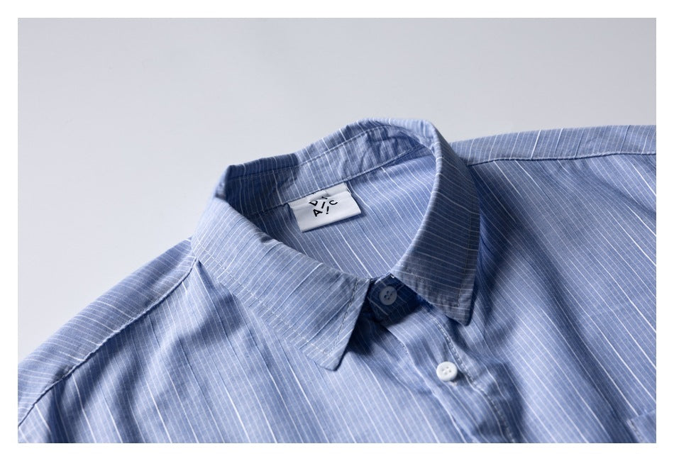 Close-up of the blue pinstriped shirt's pointed collar, white buttons, and sewn-in neck label.