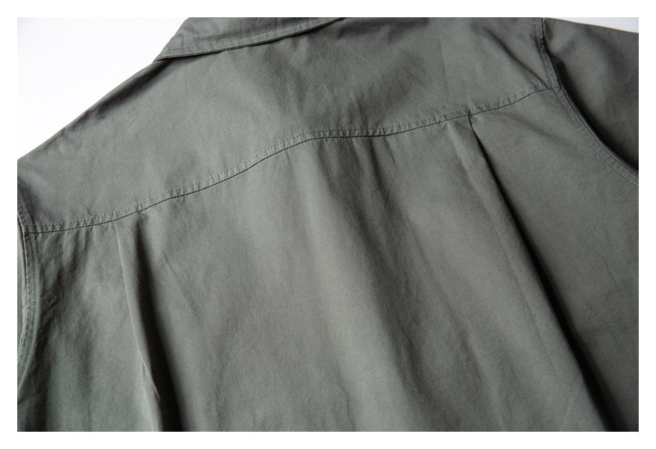 Close-up of the charcoal-gray shirt back, showing the yoke seam and pleats below it.