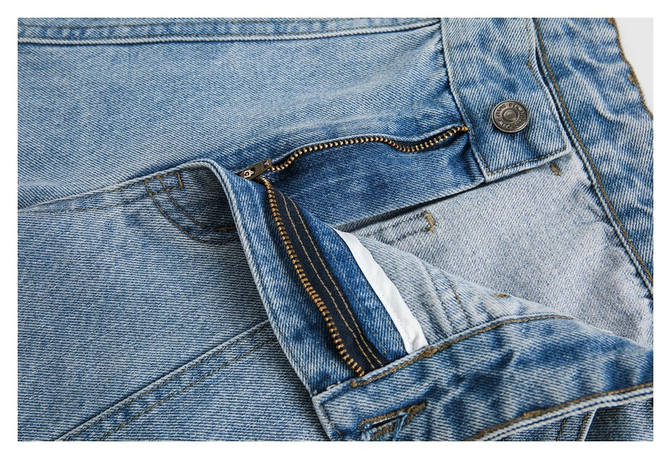 Close-up of the shorts' open zipper fly, metal button and contrast stitching.