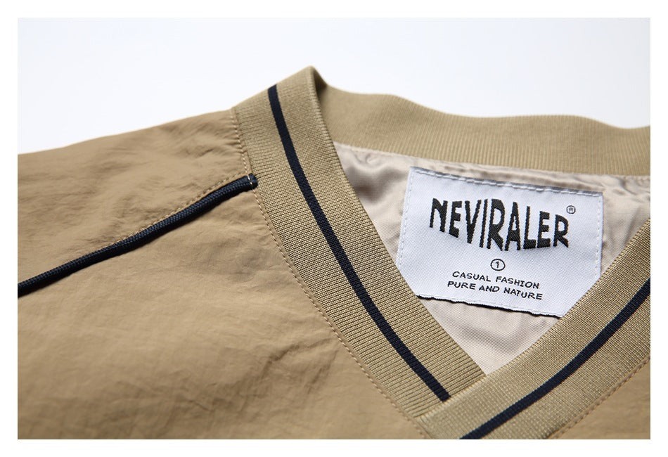 Close-up of a tan garment's V-neck collar, navy stripe trim, and visible neck label.