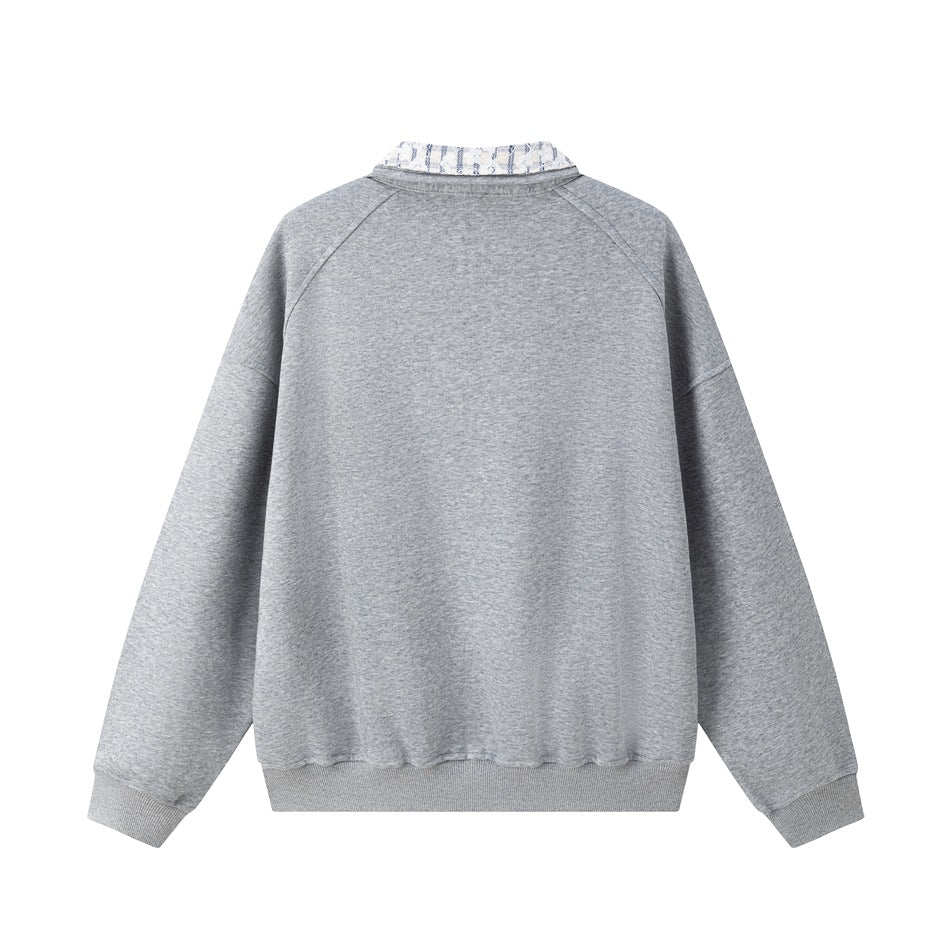 Back view of a light gray pullover laid flat, with raglan sleeves, ribbed cuffs and hem, and a patterned collar.