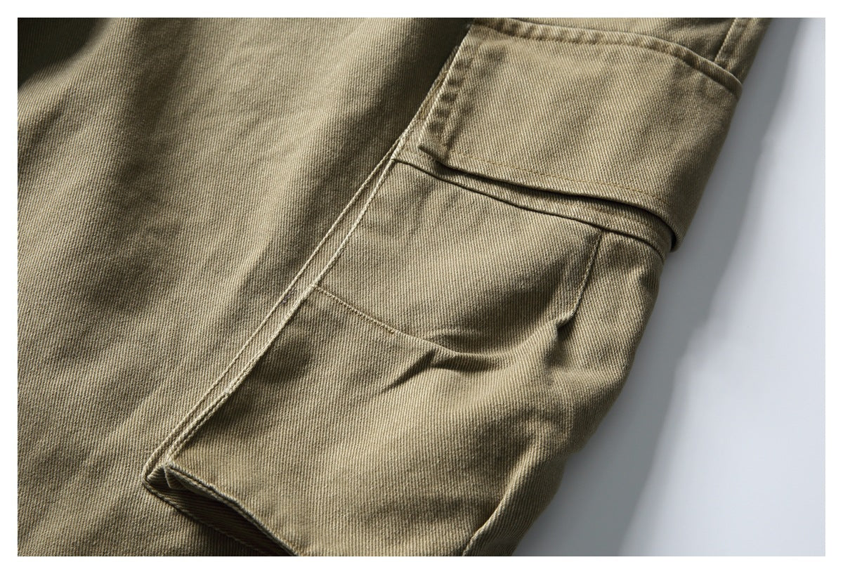 Close-up of a flap cargo pocket and seams on a tan twill garment.