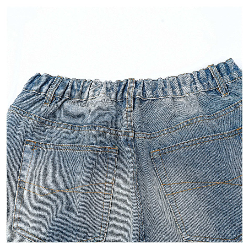 Cropped rear view of faded blue jeans showing the elastic waistband and two stitched back pockets.