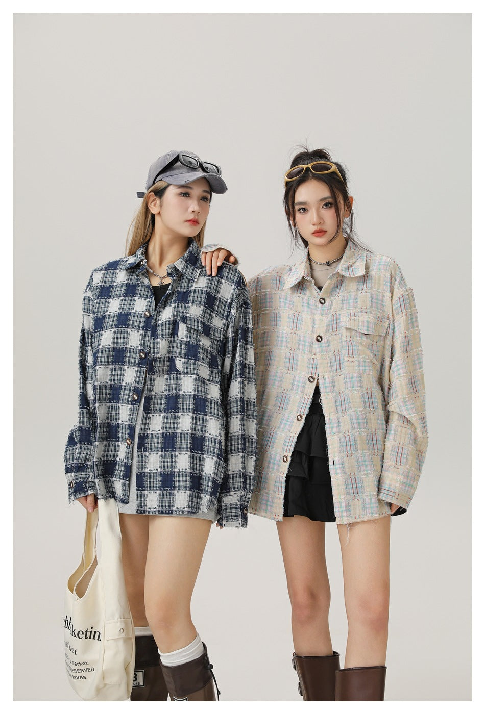 Two models wear oversized frayed plaid shirts: one navy and white, the other cream with pastel accents.