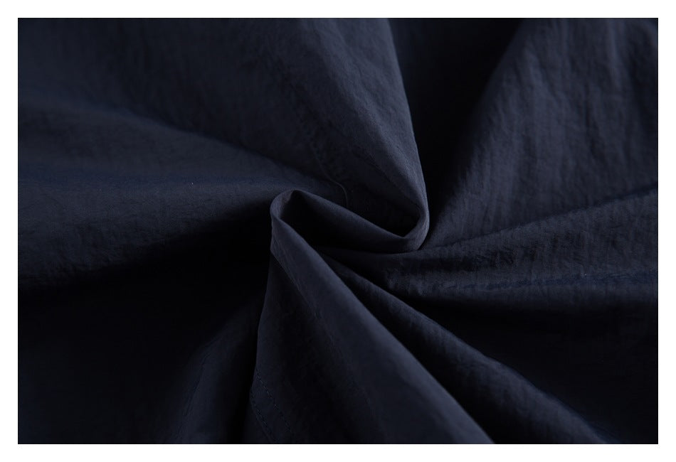 Close-up of folded solid navy shirt fabric and stitching.