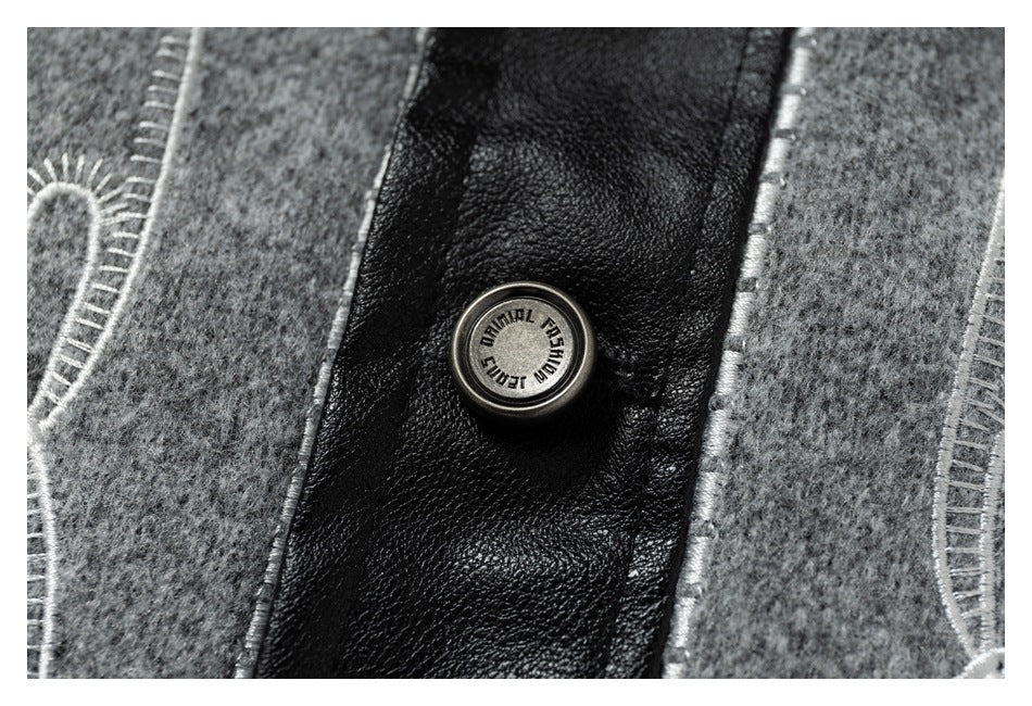 Close-up of a round button with English lettering on black trim between gray jacket panels.