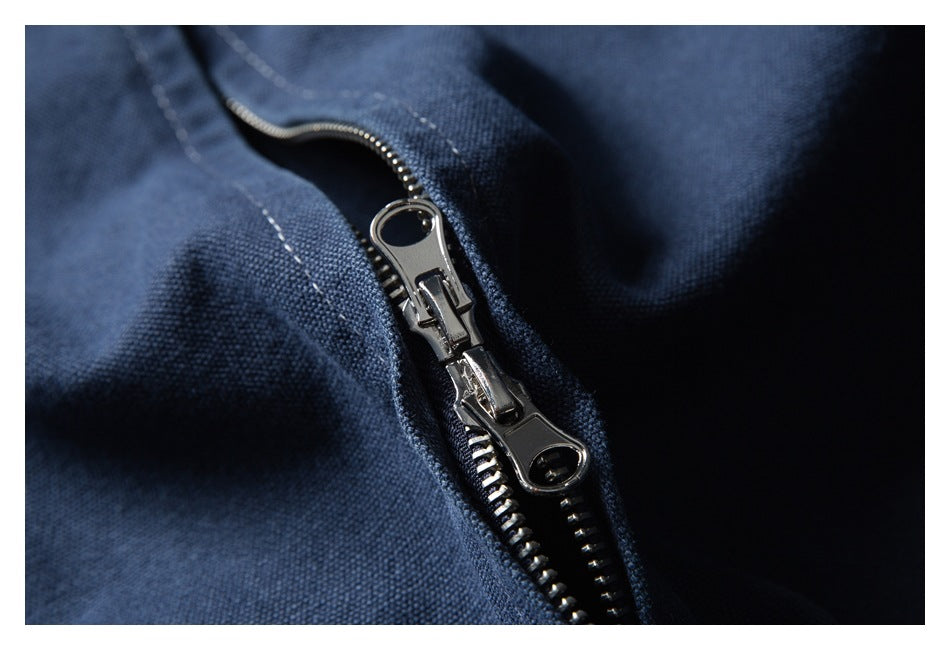 Close-up of a shiny double-pull zipper on dark navy fabric.