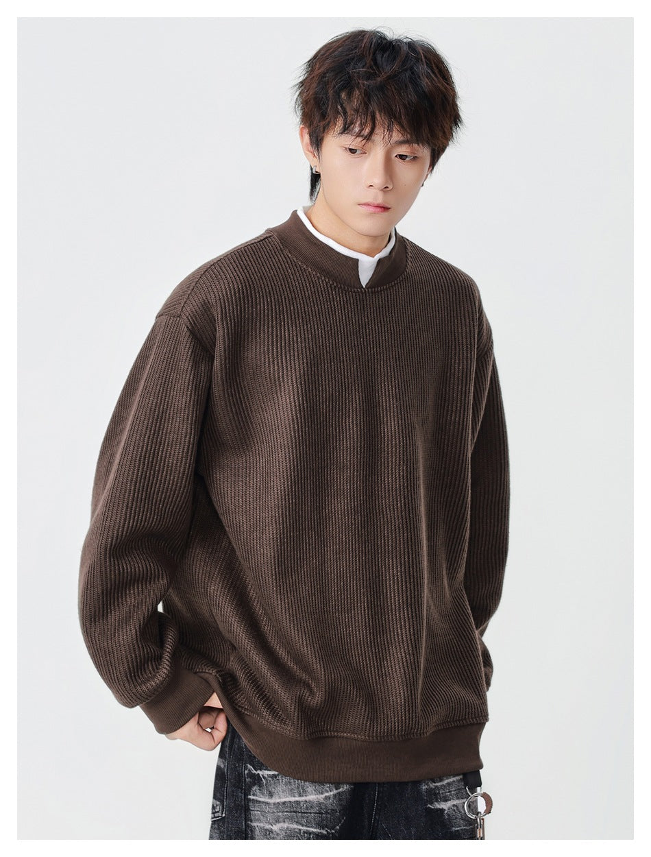 Model wearing an oversized dark brown ribbed sweatshirt with a stand collar and ribbed cuffs and hem.