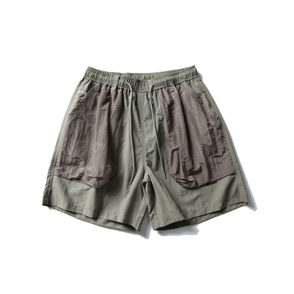Green-gray drawstring shorts with large taupe crinkled patch pockets, flat lay front view