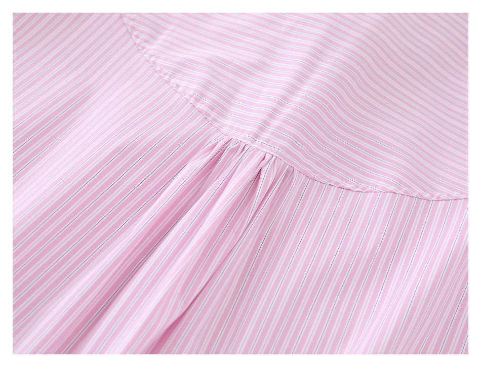 Close-up of a pink-and-white striped garment showing a curved yoke seam and gathered fabric.