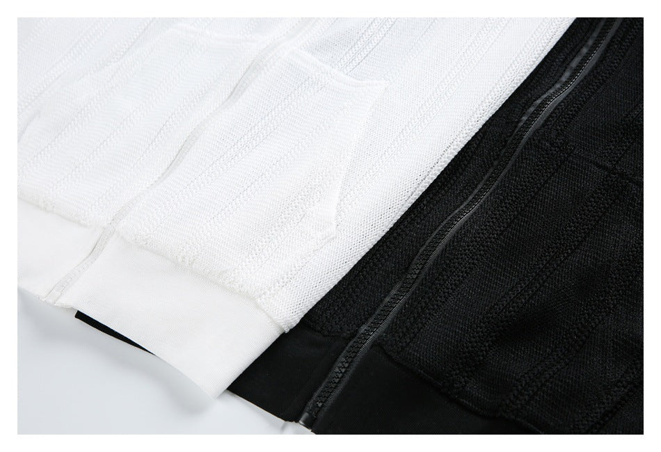 Close-up of white and black knit hoodie hems and a black zipper.