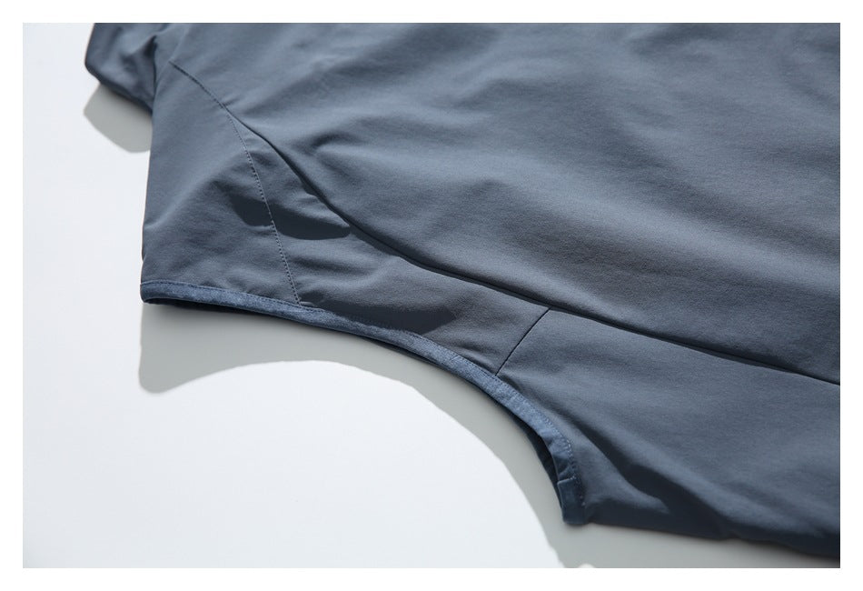 Close-up of a blue-gray garment's armhole edge and curved side seams.