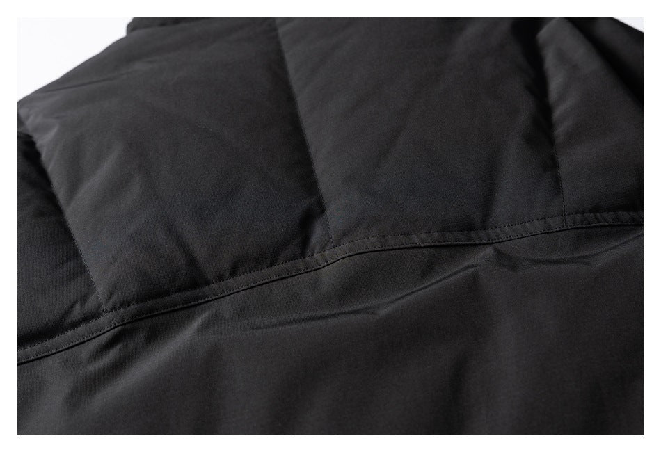 Close-up of a black garment's curved stitched seam joining panels across the back.