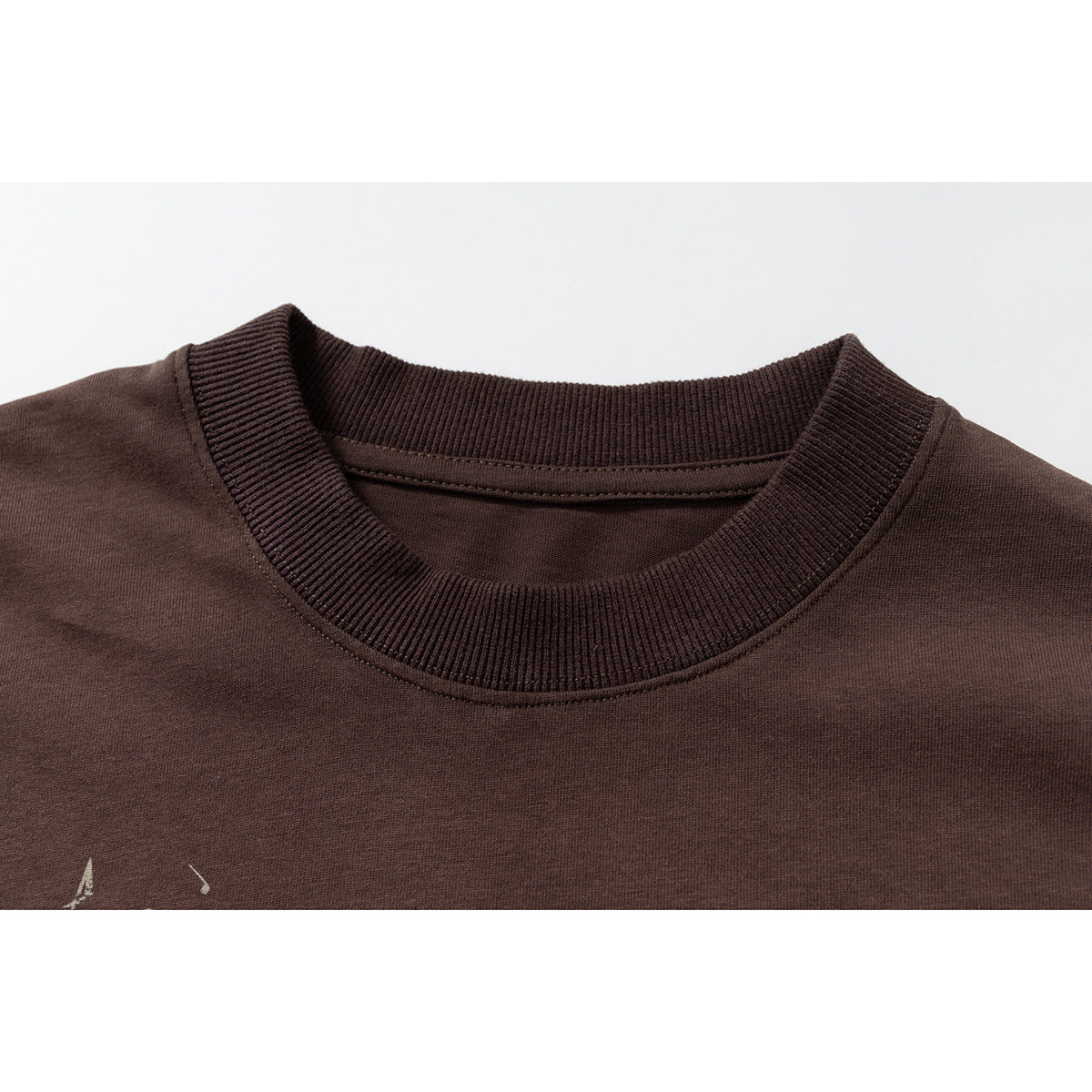Close-up of a dark brown T-shirt's ribbed crew neck and shoulder seams.