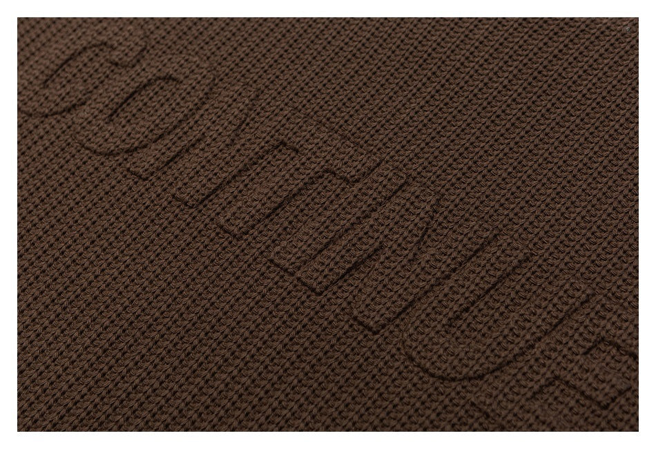 Close-up showing the brown sweater's raised knit texture.