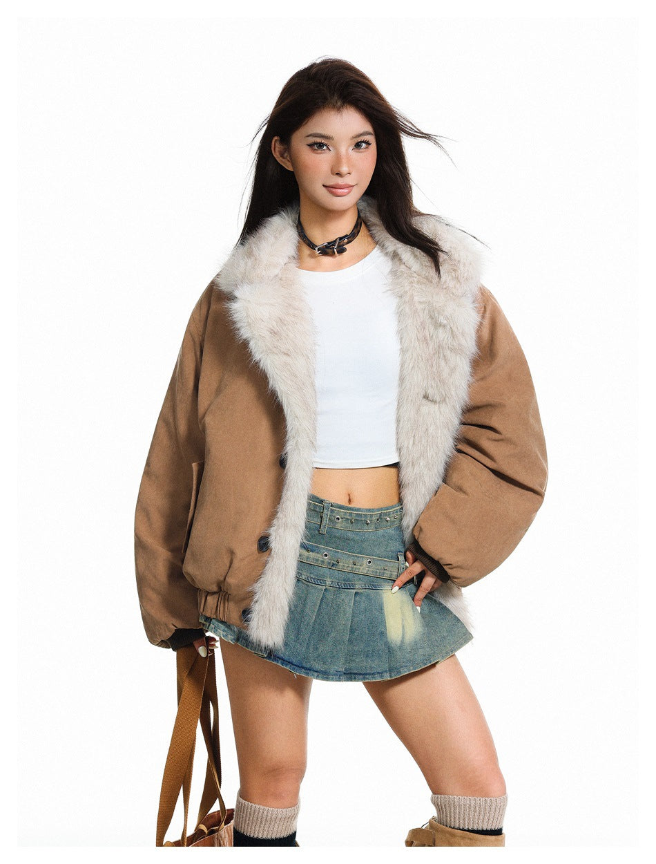Model wearing open khaki jacket with fur-like collar and trim, white crop top and pleated denim skirt
