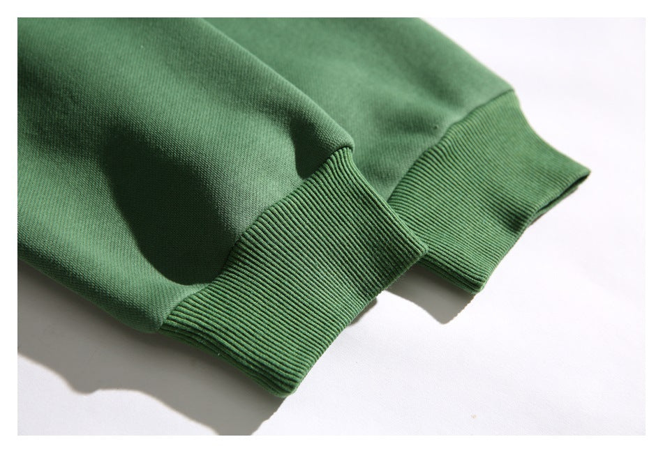 Close-up of a green sweatshirt sleeve with a wide ribbed cuff.