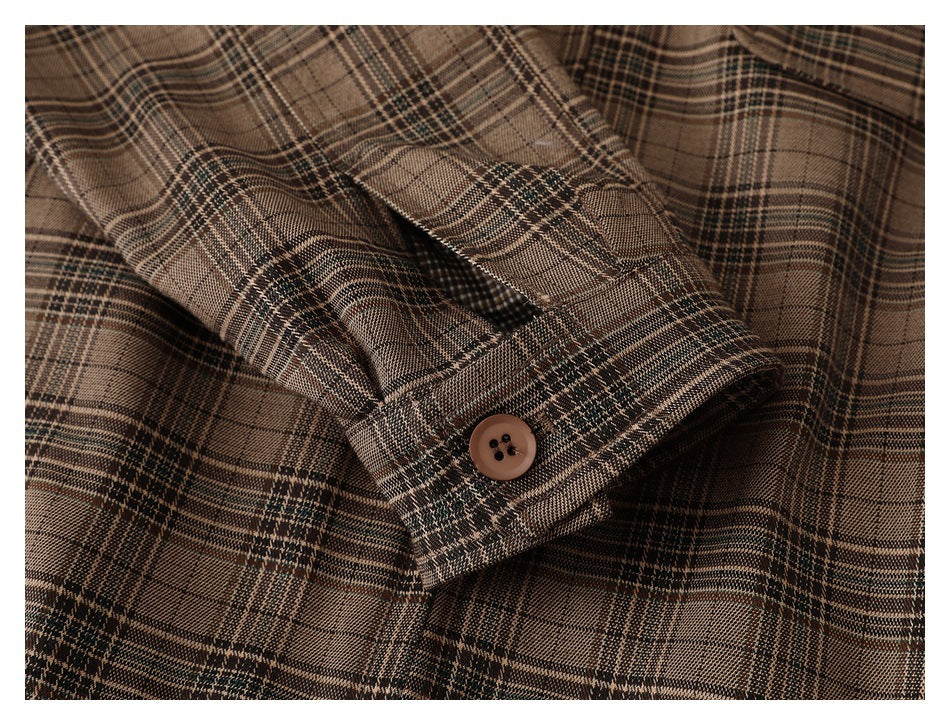 Close-up of a brown plaid jacket sleeve cuff with a button and buttonhole.