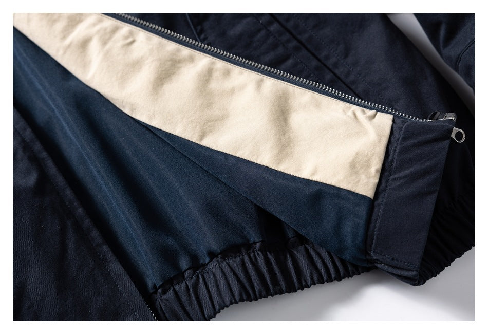 Close-up of the dark navy jacket interior with a cream lining panel, zipper, and gathered elastic hem.
