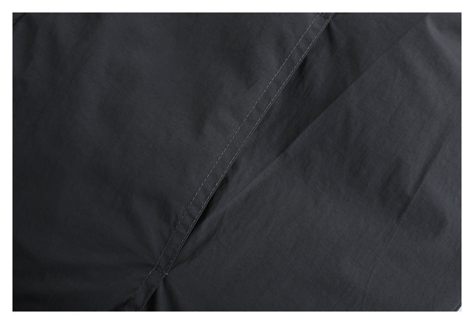 Close-up of black jacket fabric with a stitched seam.