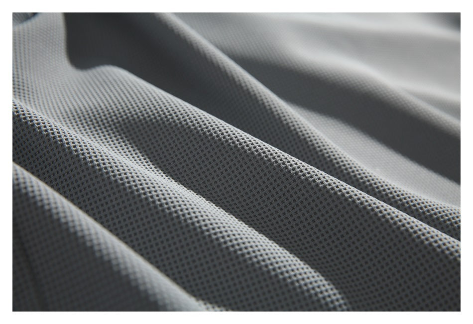 Close-up of gray fabric with a small, raised grid texture draped in folds.