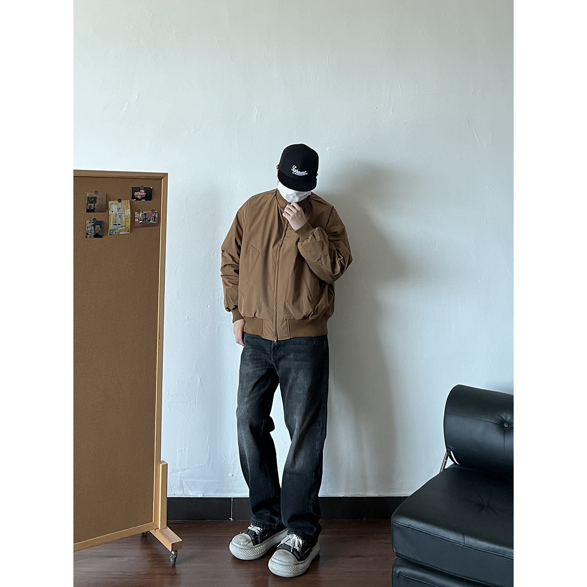 Person wearing a brown zip-front jacket with ribbed cuffs and hem, shown with dark jeans and sneakers.