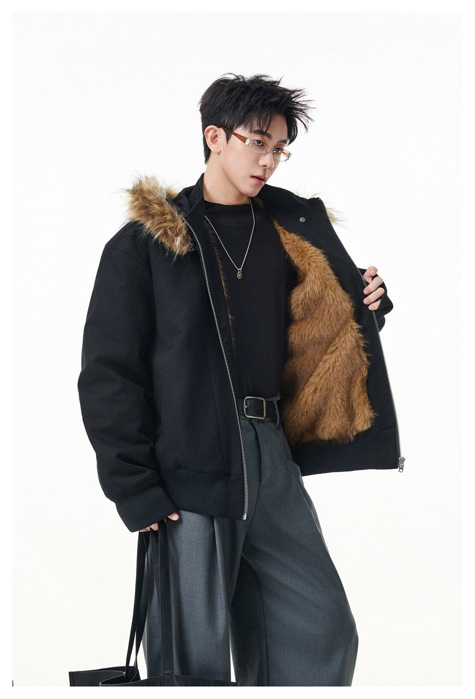 Model opening a black hooded jacket to show its brown faux-fur lining and trim.
