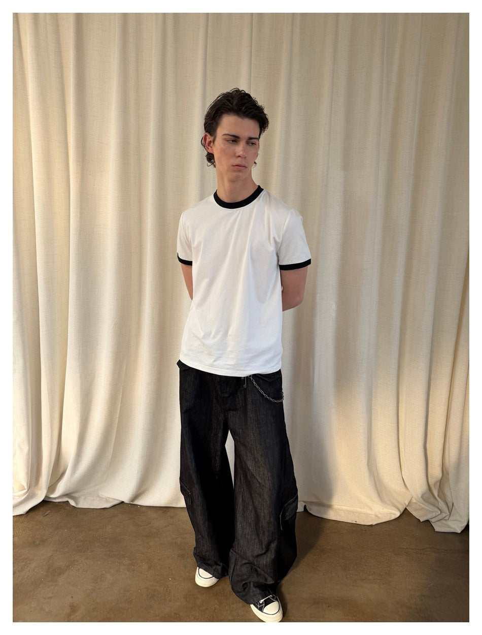 Model wearing a white T-shirt with black contrast neckline and sleeve cuffs, shown from the front.