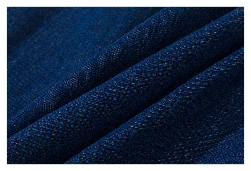 Close-up of dark blue fabric with a fine textured weave and soft diagonal folds.