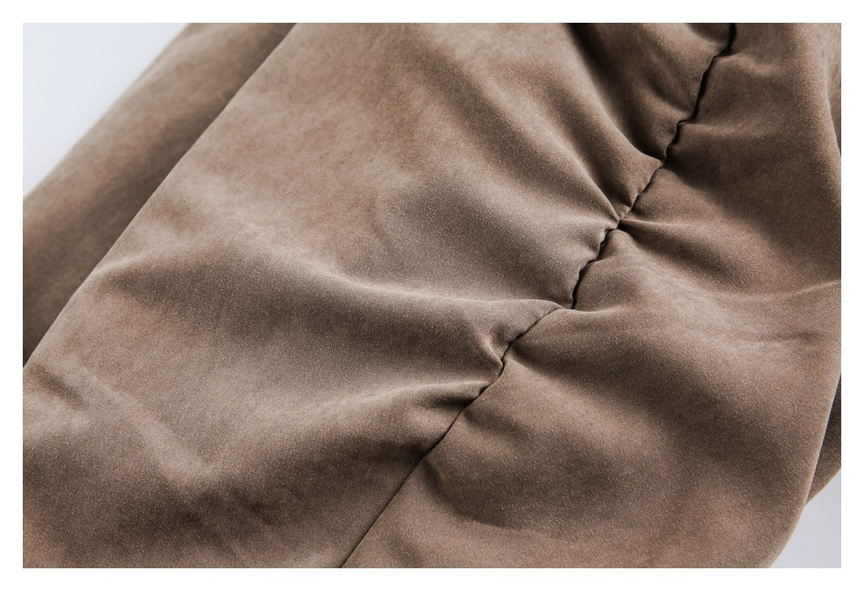 Close-up of a brown jacket's softly padded panels and stitched seam.